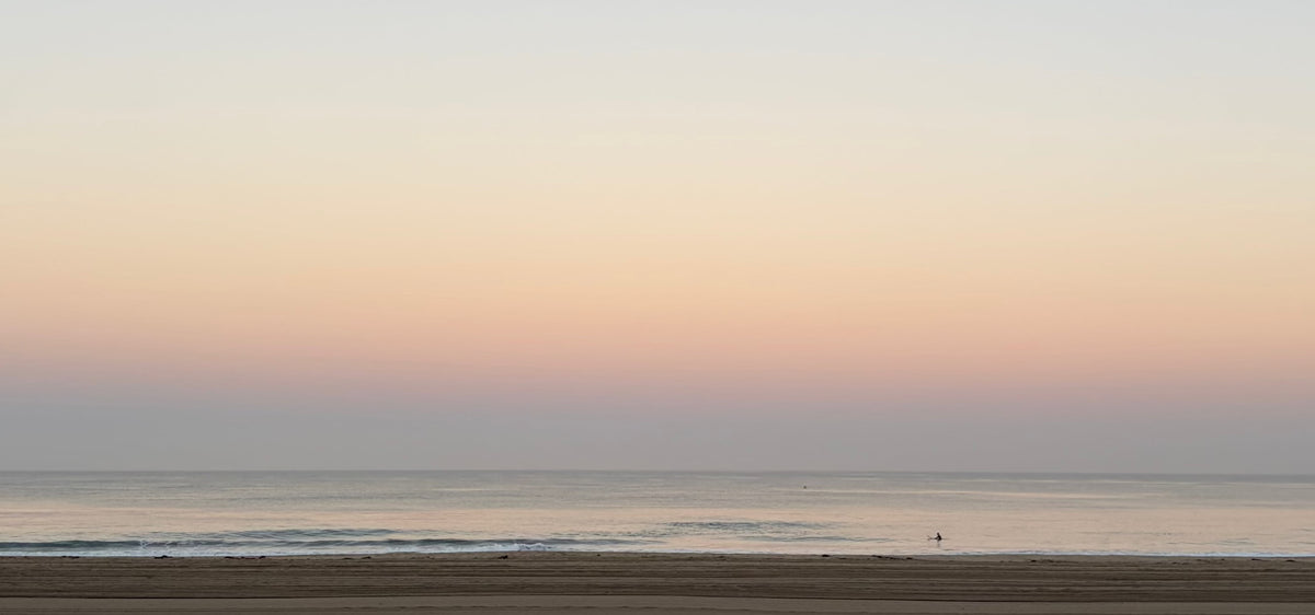 Calm ocean at dawn over an empty beach
